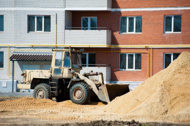 Eskisinin tamiri ve yeni bir asfalt yol inşaatı. Yeni yol inşaatında kazıcılar, grevciler ve yol silindirleri çalışıyor.