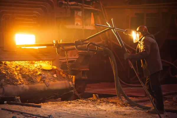 Metal structures and buildings of the old metallurgical plant inside and outside. The process of melting metal. Steelworker at work. Products of the metallurgical enterprise.
