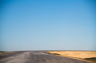 Eskisinin tamiri ve yeni bir asfalt yol inşaatı. Yeni yol inşaatında kazıcılar, grevciler ve yol silindirleri çalışıyor.