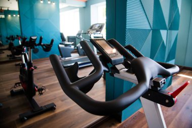 Modern spor salonunun içi ekipmanlarla dolu. Halterler, dambıllar, koşu bantları, kardiyo ekipmanları