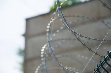 Hapishane duvarlarının etrafına dikenli teller gerilmiş.