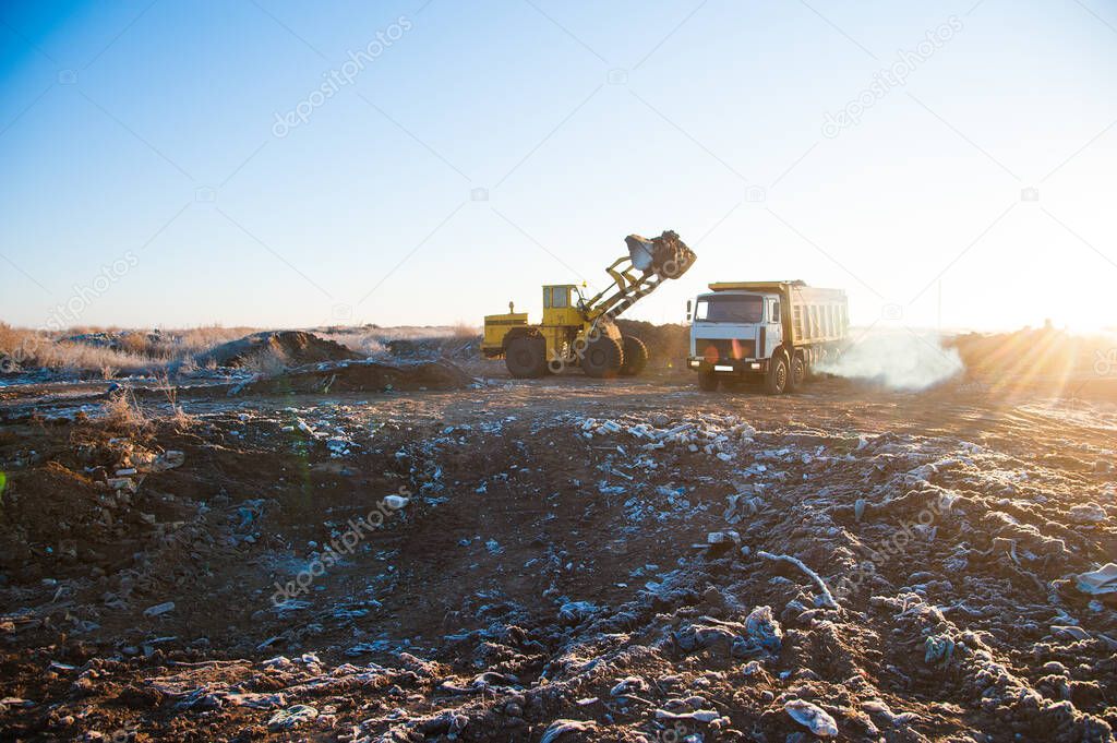 Bulldozer removes a wild dump near the city. Ecology