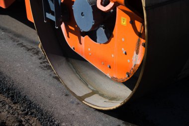 Eskisinin tamiri ve yeni bir asfalt yol inşaatı. Yeni yol inşaatında kazıcılar, grevciler ve yol silindirleri çalışıyor.