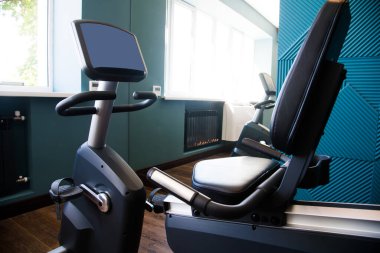 Modern spor salonunun içi ekipmanlarla dolu. Halterler, dambıllar, koşu bantları, kardiyo ekipmanları