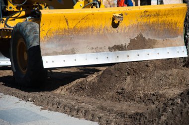 Eskisinin tamiri ve yeni bir asfalt yol inşaatı. Yeni yol inşaatında kazıcılar, grevciler ve yol silindirleri çalışıyor.