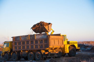 Buldozer şehrin yakınındaki vahşi bir çöplüğü temizliyor. Ekoloji