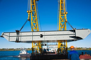 Limanda yükleniyor. Mavi gökyüzü arka planında yüzen iskele vinci. Zincirler ve kancalar, iskele tarafında yükleme için askıları olan yukarı kaldırın.