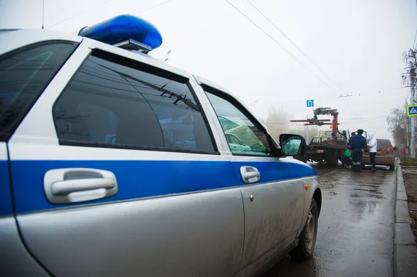 Traffic police officers on the street lifting the car on the tow truck for taking away