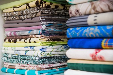 Mağazadaki raflarda renkli havlular var.