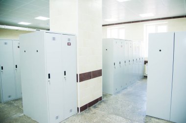 Spor kulübünde, okulda, bölümde boş bir soyunma odası. Sıralı dolaplar, numaralar, kilitler ve duş..