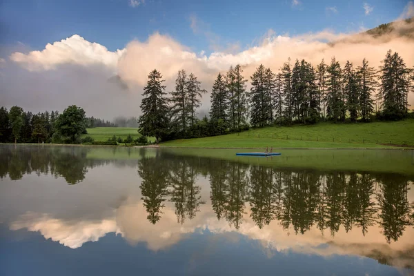 Mattina nebbiosa sul lago, con belle nuvole e riflessi — Foto Stock