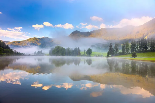 Nevoeiro paisagem matinal em Alpes montanha e lago com reflectio — Fotografia de Stock