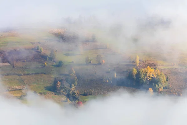 Vista aerea - Nebbia nella valle delle montagne con alberi colorati — Foto Stock
