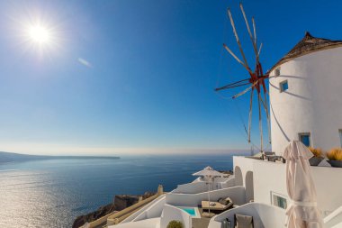 Santorini adasında ünlü yel değirmeni, Yunanistan 'da seyahat. Beyaz değirmenin güzel manzarası, deniz ve gerçek güneş. Yunan adası Santorini, Avrupa 'daki küçük Oia kasabası