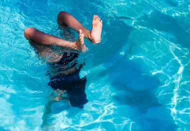 Güzel atletik güneş tabaklanmış kız tatilde bir yüzme havuzunda bir handstand yapma