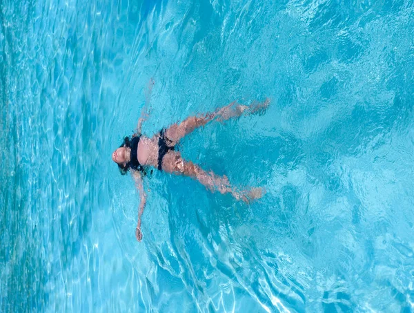 Szép sportos v. cserzett lány floatingin egy medence nyaralni — Stock Fotó