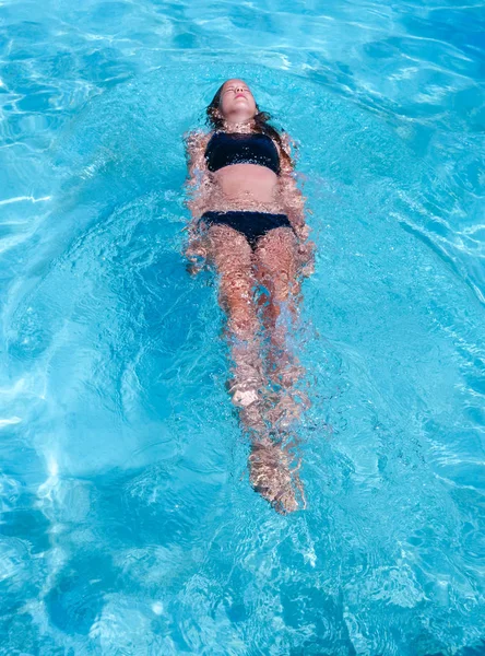 Szép sportos nap cserzett lány úszó egy uszoda nyaralni — Stock Fotó