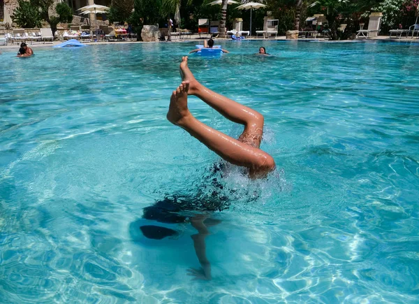 Güzel atletik güneş tabaklanmış kız tatilde bir yüzme havuzunda bir handstand yapma