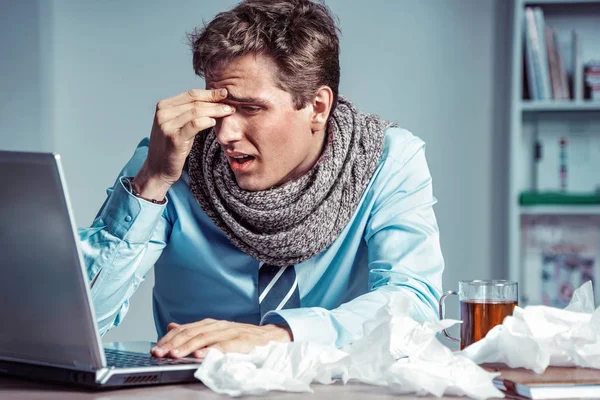 Young office man with pain in his head or an eye. Photo of sick man suffering from stress or a headache grimacing in pain. Business concept