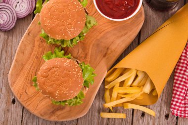 Hamburger ile kişiler üzerine ahşap masa. 