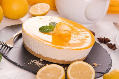 Limonlu cheesecake siyah çanak üzerinde.