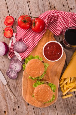 Hamburger ile kişiler üzerine ahşap masa.