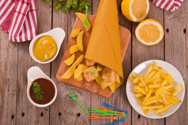 Balık ve cips kesme tahtası üzerinde.