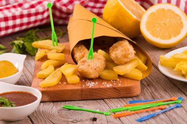 Balık ve cips kesme tahtası üzerinde.