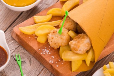 Balık ve cips kesme tahtası üzerinde.