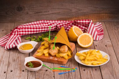 Balık ve cips kesme tahtası üzerinde.