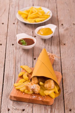 Balık ve cips kesme tahtası üzerinde.