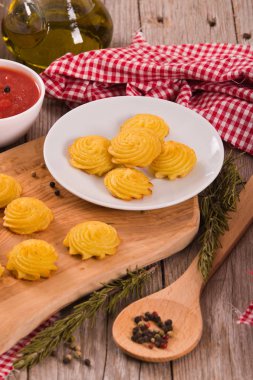 Düşes patates kesme tahtası üzerinde.