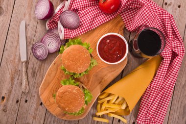 Hamburger ile kişiler üzerine ahşap masa.