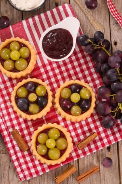 Beyaz çanak üzerinde reçelli üzümlü tart.