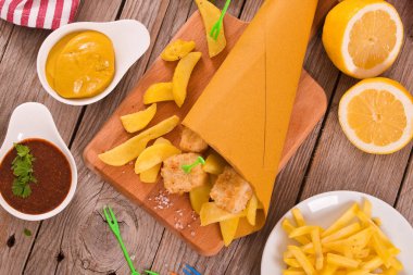 Balık ve patates kızartması ile mustrad ahşap tablo.