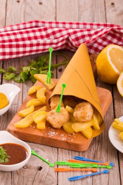 Balık ve patates kızartması ile mustrad ahşap tablo.