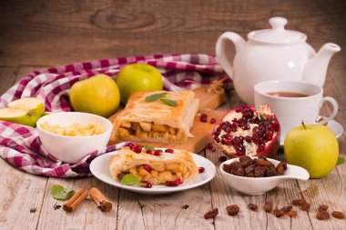 Apple strudel beyaz çanak üzerinde narlı.