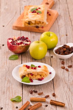 Apple strudel beyaz çanak üzerinde narlı.