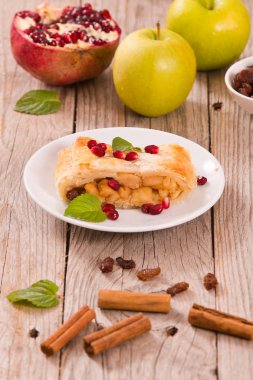Apple strudel beyaz çanak üzerinde narlı.