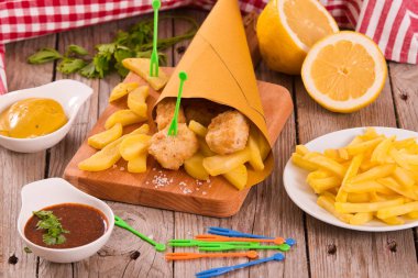 Balık ve cips kesme tahtası üzerinde.