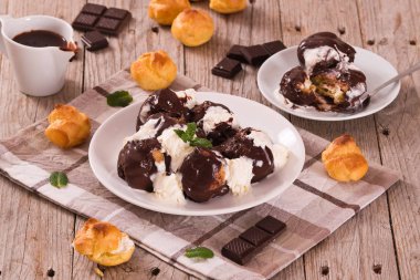 Beyaz çanak üzerinde çikolatalı profiterol.