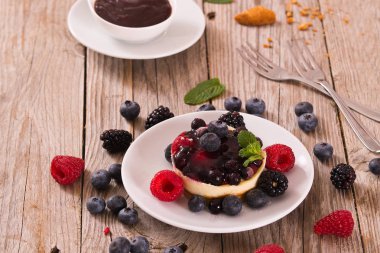 Cheesecakes üzerinde beyaz tabak karışık meyveli ile.