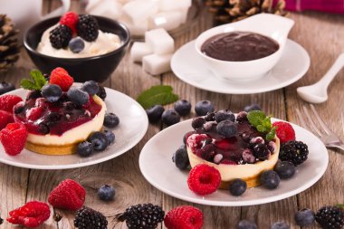Cheesecakes üzerinde beyaz tabak karışık meyveli ile.