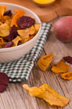 Ahşap masa üzerinde karışık sebze cips.