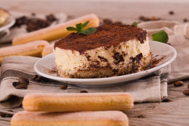 Nane ve beyaz tabak üzerine kakao ile tiramisu.