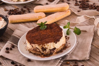 Nane ve beyaz tabak üzerine kakao ile tiramisu.