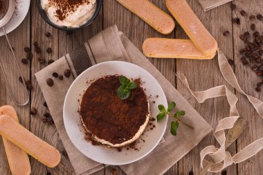 Nane ve beyaz tabak üzerine kakao ile tiramisu.