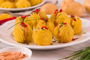 Düşes patates sandviç beyaz çanak üzerinde.