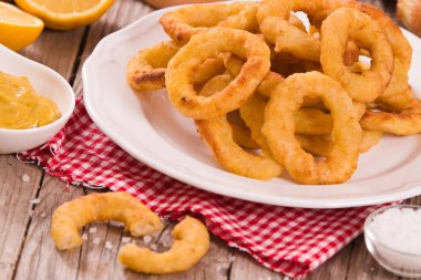 Onion rings on white dish. clipart