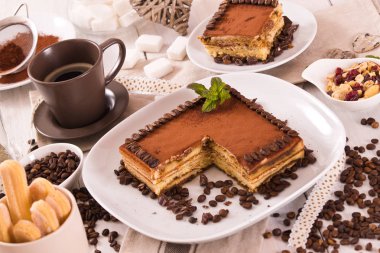 Beyaz çanak üzerinde kahve çekirdekleri ile tirayisu kek.